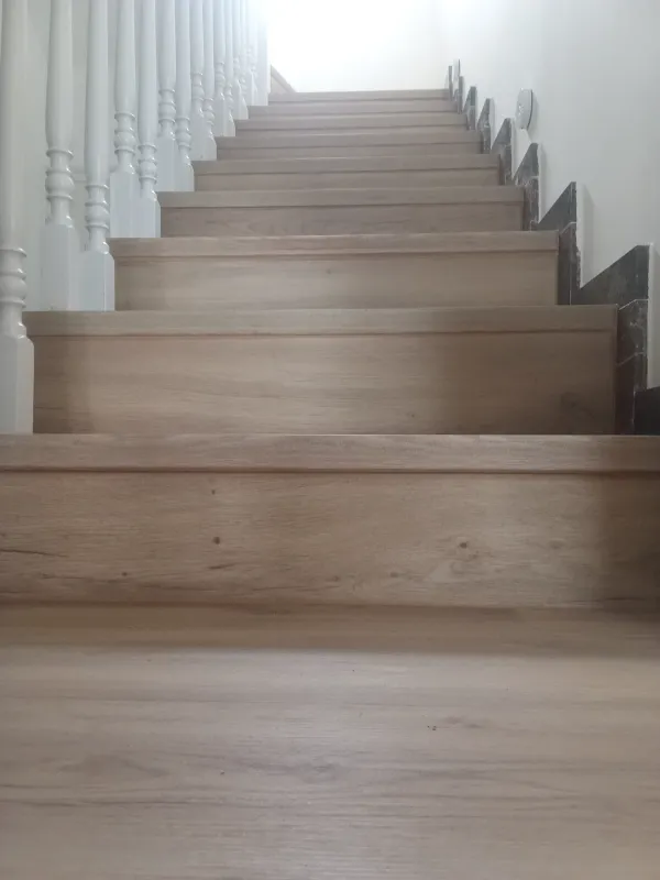 instalación de suelo laminado casa costera en Castelldefels - detalle de acabado mostrando técnica profesional