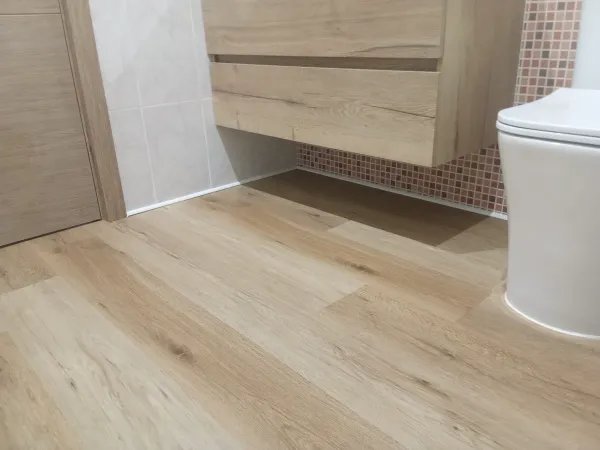 instalación de suelo laminado vivienda en Castelldefels - detalle de acabado mostrando técnica profesional